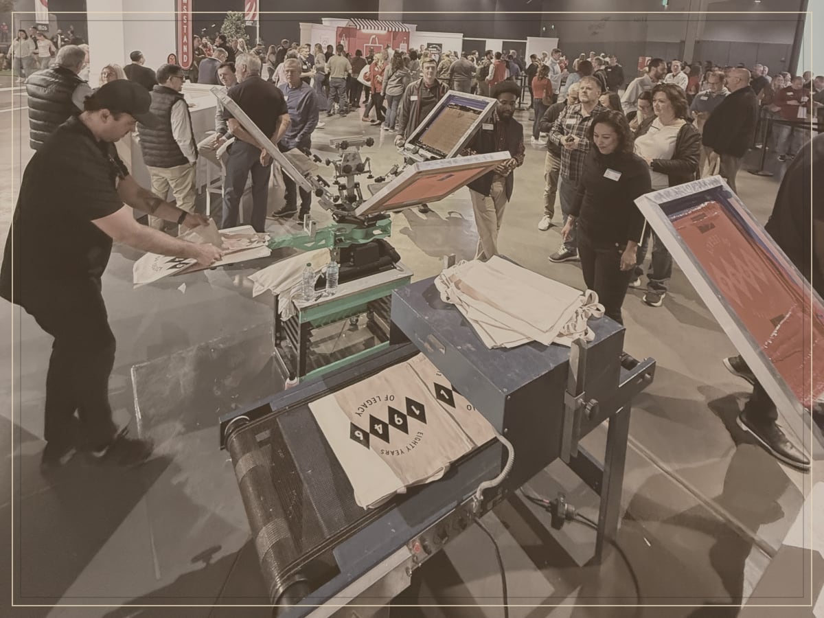 Attendees waiting at a personalization station during an evening convention event